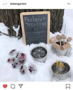 a sign that is in the snow next to some pots and pans with food