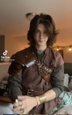 a young man dressed in armor sitting on a couch