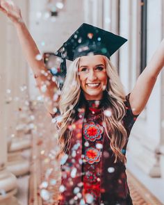 a woman wearing a graduation cap and gown is throwing confetti in the air