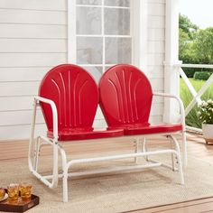 two red chairs sitting on top of a white bench