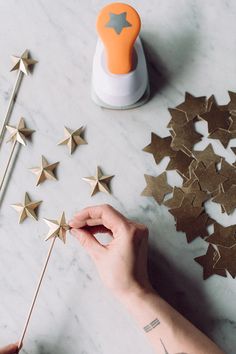 someone is making some gold stars out of paper and glue on the top of them