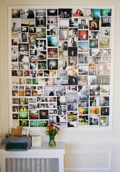 a wall covered in pictures and photos with a typewriter next to it on a table