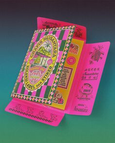 two pink and green playing cards with designs on them, one in the shape of a book