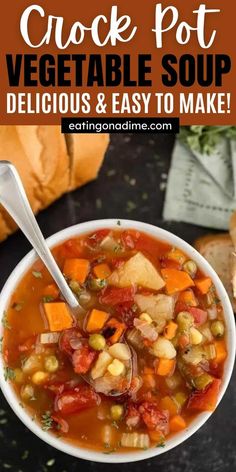 a white bowl filled with vegetable soup on top of a black table next to bread