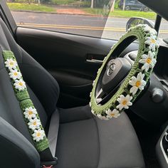 the steering wheel cover is decorated with daisies and crocheted flowers on it