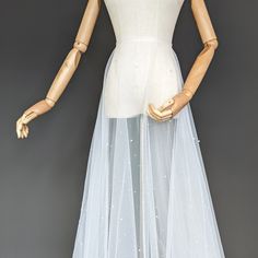 a mannequin wearing a white dress with gold hands