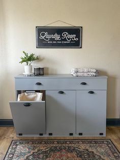 a gray cabinet with two drawers and a sign above it