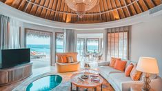 a living room filled with furniture and a flat screen tv sitting on top of a wooden ceiling