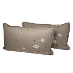 two pillows with snowflakes on them, one is brown and the other is beige