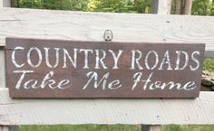 a wooden sign that says country roads take me home