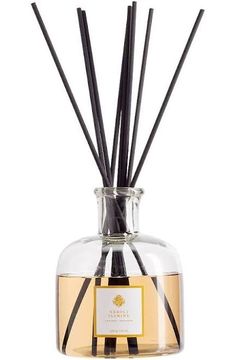 the reeds are in a clear glass vase with black and white stripes on it