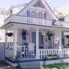 a white house with blue trim on the front porch