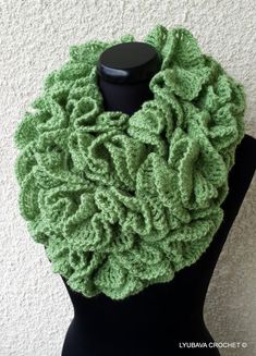 a green crocheted scarf on a mannequin