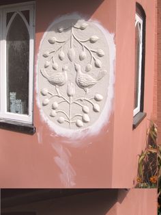 the side of a pink building with white paint on it