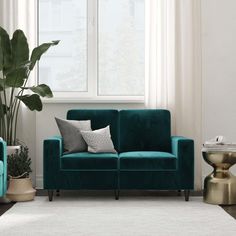 a living room scene with focus on the couch and chair in the foreground, along with a potted plant