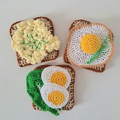 three crocheted toast with fried eggs on them