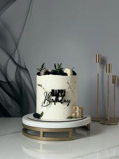 a birthday cake on a stand with candles