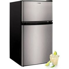 a stainless steel refrigerator next to a glass filled with ice and limes on a white background