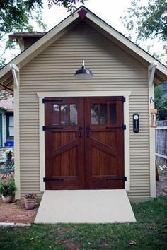 a brown garage with two doors and windows