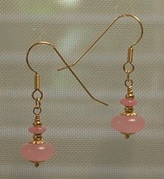 Translucent pink Czech glass and 14kg filled beads are featured in these earrings for pierced ears. All metal is 14kg filled. Each earring weighs 1.9 grams compared to a US dime weighing 2.268 grams. Size and length can be judged in the photo above as compared to a ruler and a US dime. If you are interested in these earrings and would like more photos or have any questions please feel free to contact me. I usually answer all inquiries within the hour Eastern Standard time. These earrings are rea Pink Rose Quartz Jewelry With Ear Wire, Elegant Pink Czech Glass Earrings, Delicate Pink Pierced Earrings, Pink Rose Quartz Round Earrings, Nickel Free Pink Round Bead Earrings, Pink Nickel-free Round Bead Earrings, Pink Nickel-free Round Beaded Earrings, Pink Round Beads Earrings Nickel Free, Pink Czech Glass Earrings With Ear Wire