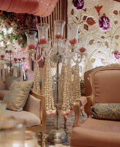 a living room filled with lots of furniture and flowers in vases on the floor