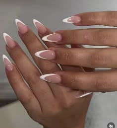 a woman's hands with white and pink manicures on their fingertipss