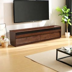 a flat screen tv mounted to the side of a wooden entertainment center in a living room