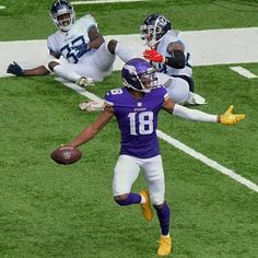 a football player is jumping in the air to catch a ball while another runs behind him