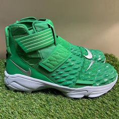 a pair of green nike sneakers sitting on top of grass