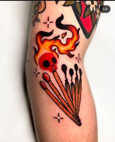 a tattoo with flames and skulls on it