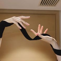 two hands reaching out to each other in front of a mirror with their arms stretched out