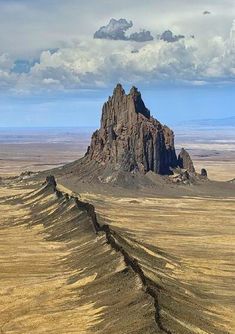 an image of a mountain range in the middle of desert land with clouds above it