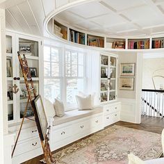 a living room filled with lots of furniture and bookshelves next to a window