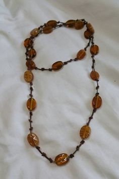 Metal Free, Boho Style 38 inch Necklace, Brown and Gold Lucite Oval Beads with Brown Knotted Cord., Costume Jewelry, Fashion Accessory This is a nice find and priced to sell.  There are no flaws on this necklace.   Check out our shop for monthly specials. We have a variety of items for every taste. Combine several of our items together to save on shipping. If you have any questions please do not hesitate to ask. I will ship outside of the US, just request a quote. Happy Shopping. I will work around the priority mail price. Just send me your zip code and I will get a quote. As shop owners we will do our best to describe any issues or problems with our items. Since we do sell vintage and antiques there may be some flaws. Please check out the pictures very carefully and feel free to ask any q Adjustable Single Strand Brown Beads, Brown Beaded Necklaces With Oval Beads, Brown Beaded Necklace With Oval Beads, Adjustable Brown Beaded Necklaces With Oval Beads, Bohemian Oval Beaded Necklaces, Adjustable Oval Beads Necklace For Beach, Bohemian Oval Beaded Necklace, Adjustable Brown Long Necklace With Large Beads, Adjustable Oval Beaded Necklace