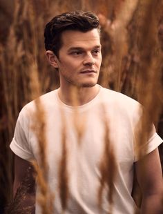 a man standing in tall grass looking at the camera