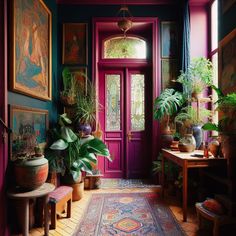 an entryway with potted plants and paintings on the wall