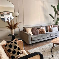 a living room filled with furniture and a large mirror