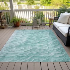 a blue rug on a wooden deck with white furniture