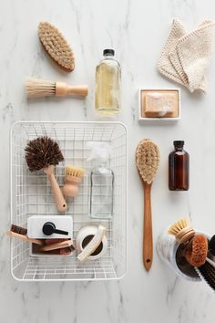 various items are arranged on a white counter top, including hair brushes and soaps