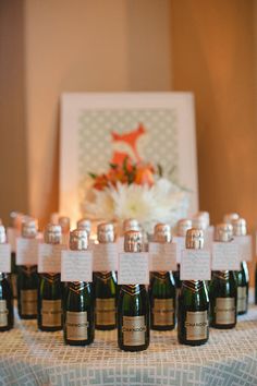 there are many bottles of wine on the table with place cards in front of them