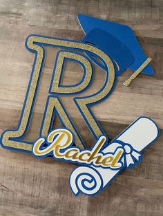 a wooden table topped with a blue and gold graduation hat next to a pair of scissors