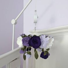 purple and white flowers are hanging from the banister in this baby's room