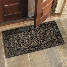 a door mat on the floor in front of a wooden door