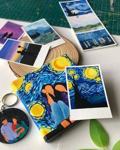 a couple of pictures sitting on top of a table next to some magnets and a keychain