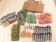 an assortment of snacks and condiments are laid out on a white tablecloth