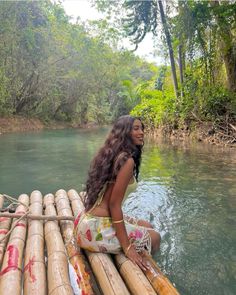 a woman is sitting on bamboo raft in the water