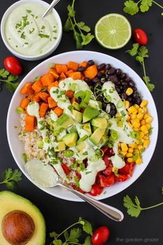 a salad with avocado, tomatoes, corn, black beans and cilantro