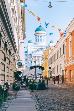 an alley way with flags and buildings in the background