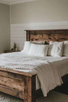 a bed with white sheets and pillows in a bedroom