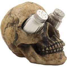 a skull head with two salt and pepper shakers in it's beakle